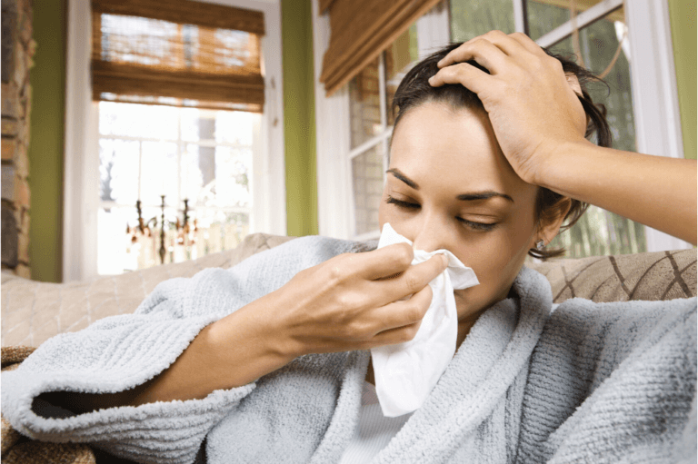 Image of young woman in robe with tissue, cold and flu season