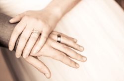 Hands of husband and wife with wedding rings