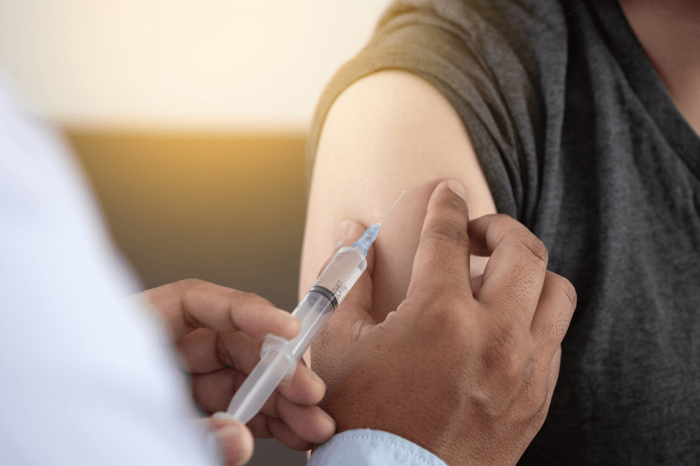 Doctor administers vaccination shot into arm of patient