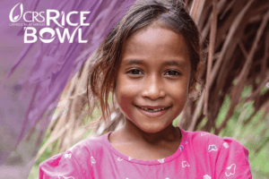 Young girl in pink with CRS Rice Bowl logo
