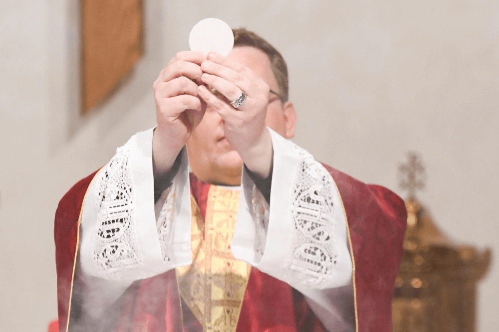 Father David Jameson elevates Host, first Mass, IHM Parish June 2022