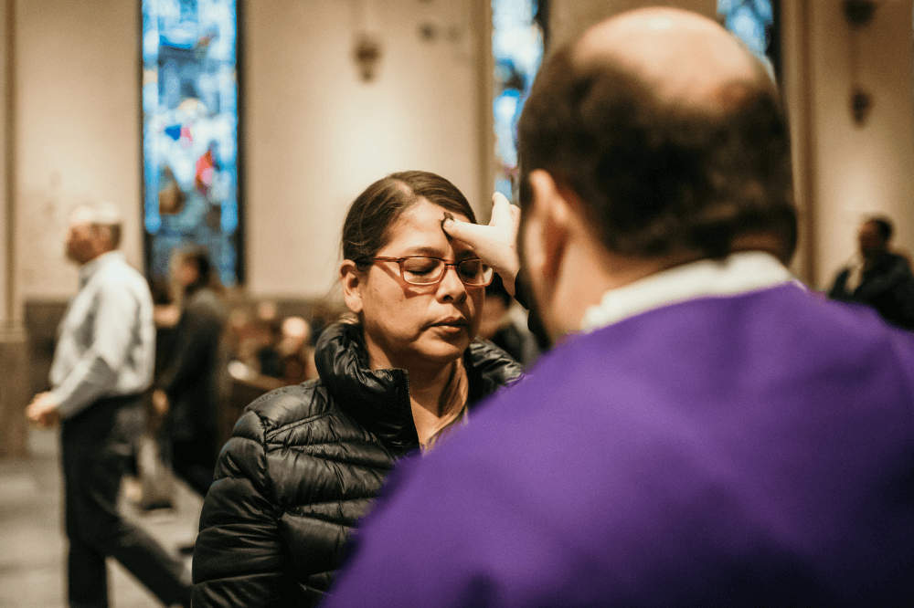 Deacon applies ashes to a parishioner's forehead at the Cathedral of Saint Andrew by Emma Rolf