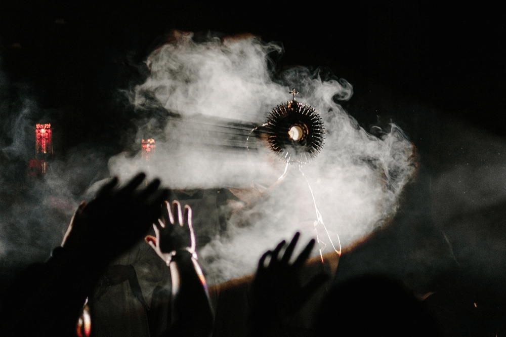 Image of Eucharistic Adoration, monstrance with smoke around it