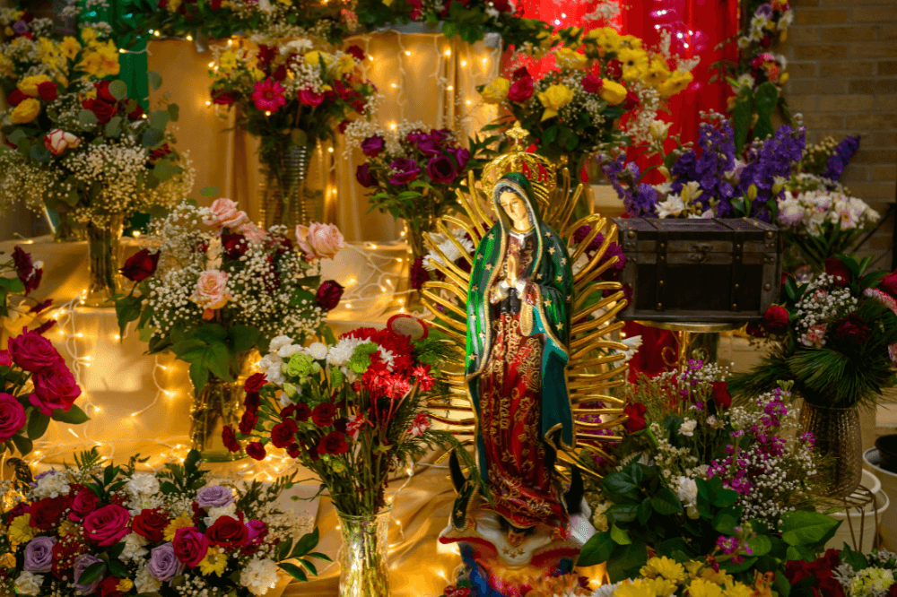 Image of Our Lady of Guadalupe statue surrounded by flowers by Dr. Eric Bouwens