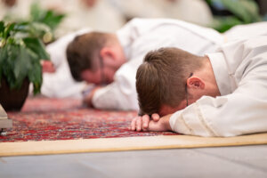 Deacon Logan McGahan and Deacon Charlie Leidel lie prostrate on the altar during the Litany of Saints
